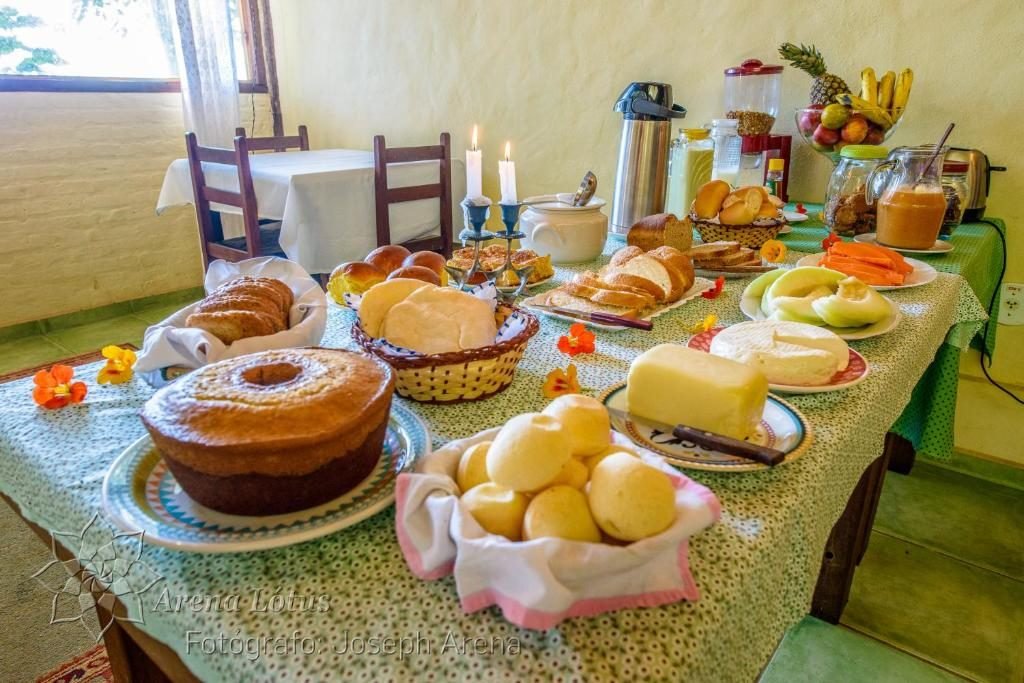 Mesa de café da manhã com bolos, pães, queijos e frutas