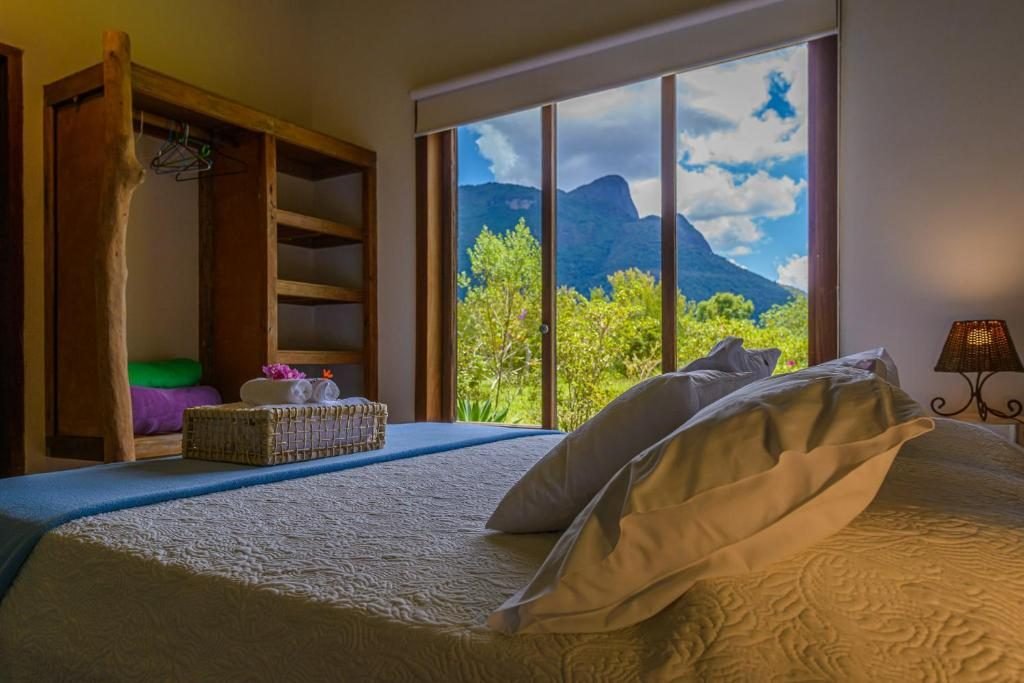 Cama de suíte com janela para o Pico do Papagaio